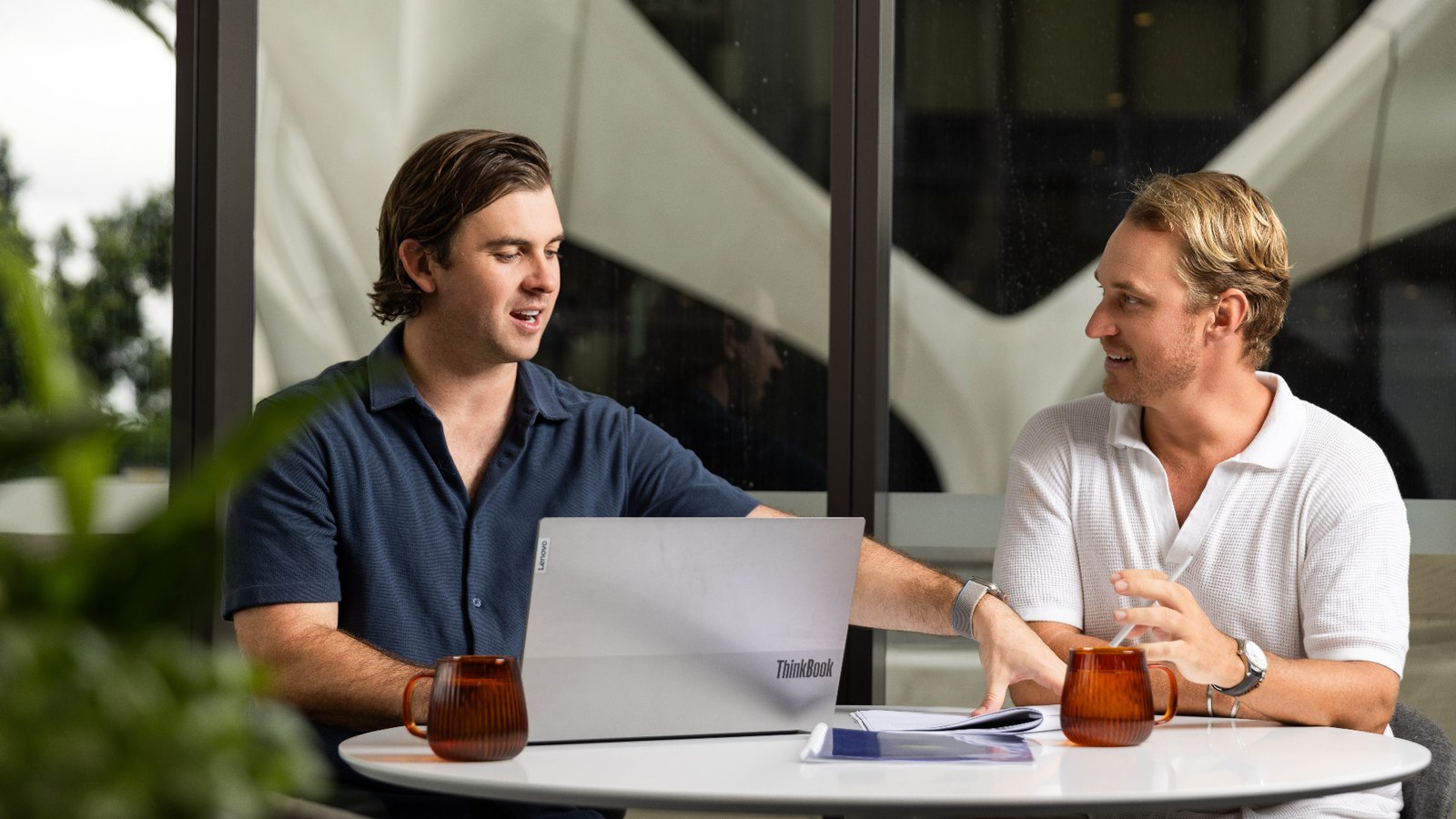 Two Wakefield Pacific advisers reviewing business performance figures with a laptop and printed reports.