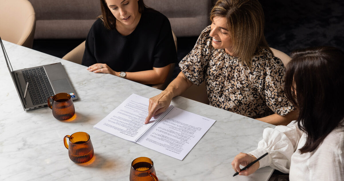 Wakefield Pacific advisers reviewing financial information around a meeting table