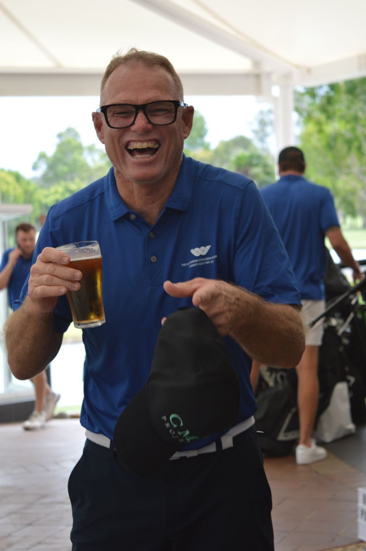 Guest laughing in the clubhouse marquee, mid-conversation
