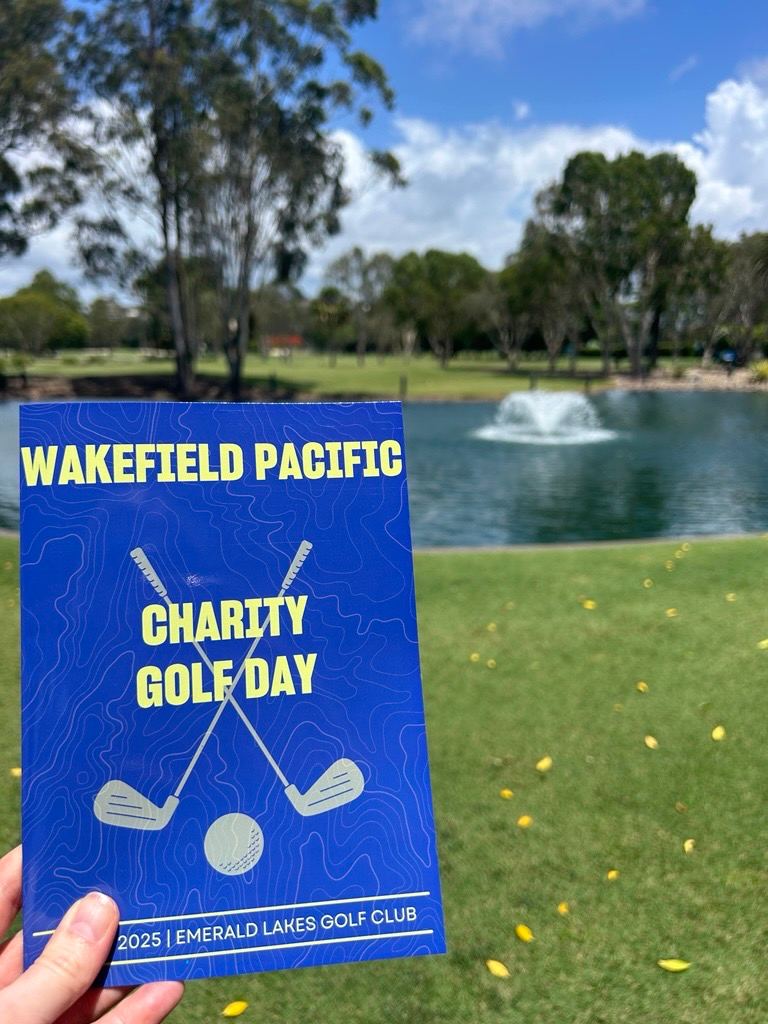 The 2025 Wakefield Pacific Charity Golf Day program in front of Emerald Lakes Golf Club